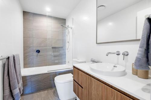 ゴールドコーストにあるVillage Palm Beach - Brand New 2 Bedroom Apartmentの白いバスルーム(洗面台、トイレ付)