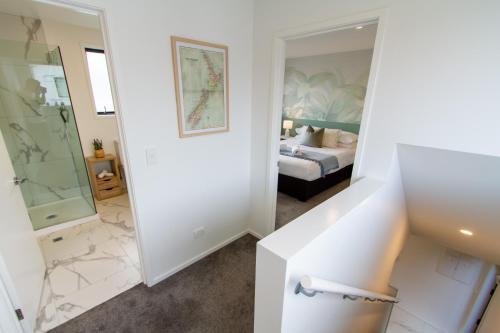 ein Schlafzimmer mit einem Bett und ein Badezimmer mit einem Spiegel in der Unterkunft 1 Bedroom Gem with Hagley Park at your doorstep in Christchurch