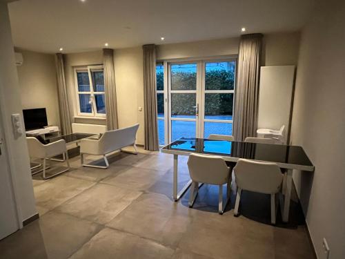 uma sala de jantar com uma mesa e cadeiras e uma janela em Apartment Venlose heide em Venlo