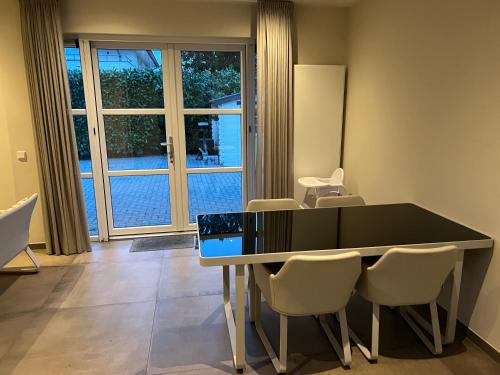 uma sala de jantar com uma mesa e cadeiras e uma janela em Apartment Venlose heide em Venlo