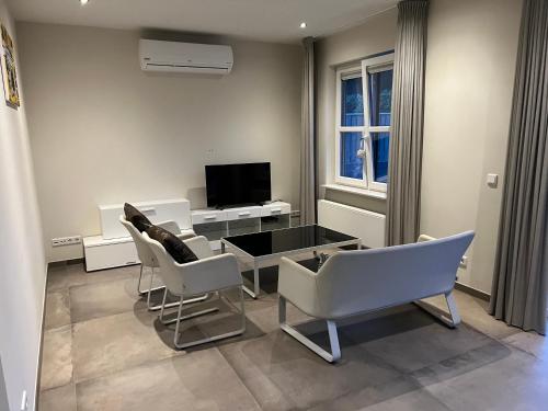 uma sala de estar com uma mesa e cadeiras e uma televisão em Apartment Venlose heide em Venlo