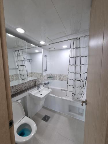 a bathroom with a toilet and a sink and a tub at Luxury ocean view in Busan
