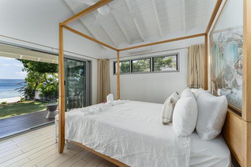 1 dormitorio con 1 cama grande y balcón en Solwota Sands, en Port Vila