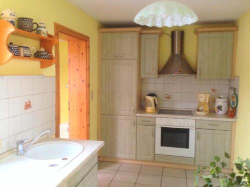 a kitchen with a sink and a stove at Bungalow mit Kamin in Ribnitz-Damgarten in Ribnitz-Damgarten