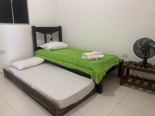 een slaapkamer met 2 bedden met groene lakens en een ventilator bij Centro de convenções próx in Recife