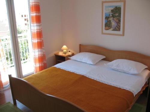 - une chambre avec un grand lit et une fenêtre dans l'établissement Apartment mit Balkon, à Petrčane