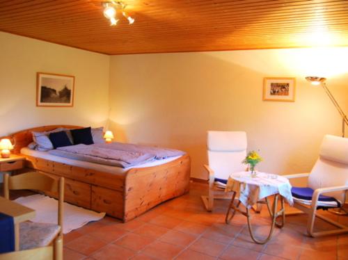 a bedroom with a bed and a table and chairs at Ferienhaus mit Garten am Bodstedter Bodden in Bodstedt