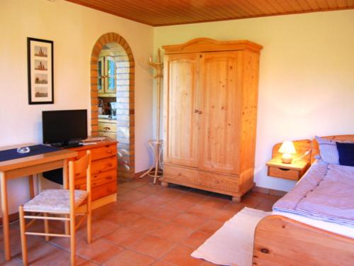 a bedroom with a desk with a computer and a bed at Ferienhaus mit Garten am Bodstedter Bodden in Bodstedt