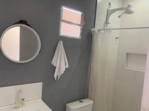 een badkamer met een spiegel, een toilet en een douche bij Centro de convenções próx in Recife