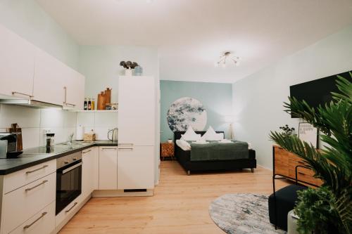 eine Küche mit weißen Schränken und ein Wohnzimmer mit einem Sofa in der Unterkunft Schicke Ferienwohnung mit direkter Innenstadtlage in Bingen am Rhein