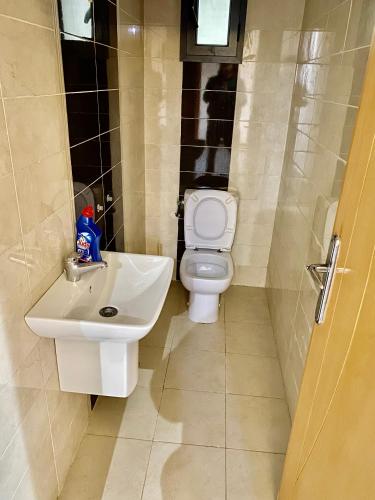 a bathroom with a white sink and a toilet at Villa Mina résidence in Kelibia