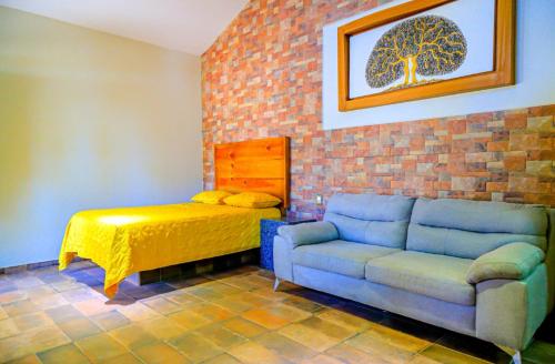 sala de estar con sofá y cama en La Ocotera hotel de montaña, en La Esperanza