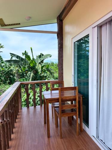 d'un balcon en bois avec une table en bois et une fenêtre. dans l'établissement Clubmiller Guesthouse, à Puerto Princesa