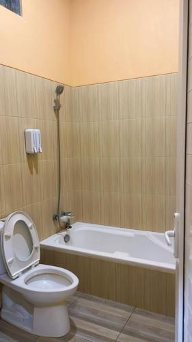 a bathroom with a toilet and a bath tub at Abaka Hotel in Lamglumpang