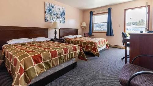 a hotel room with two beds and a desk at Best Travel Inn Philipsburg in Philipsburg