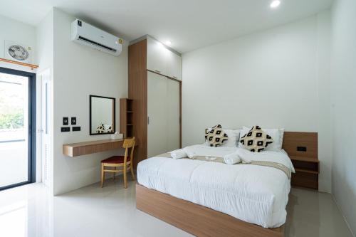 a bedroom with a bed and a desk in it at T-OneHome in Phetchabun