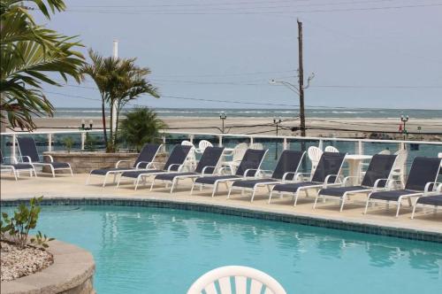 un grupo de sillas sentadas junto a una piscina en Champagne Isle Resort Unit 107, en Wildwood