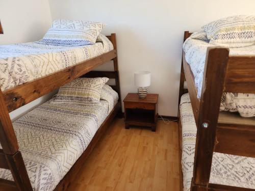 a bedroom with two bunk beds and a lamp at NEW HOTEL CRUZ DEL SUR in Concepción