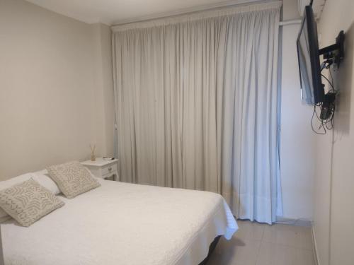 - une chambre avec un lit blanc et une fenêtre dans l'établissement Departamento moderno para 2 personas, à Santiago del Estero