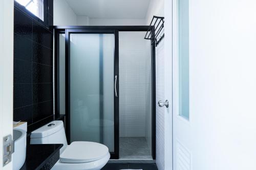 a bathroom with a glass shower with a toilet at T-OneHome in Phetchabun