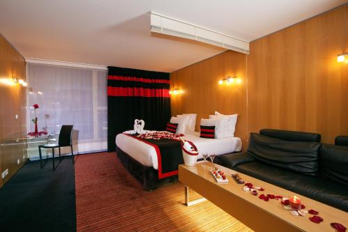 a hotel room with a bed and a couch at Residhome Suites Paris Sénart in Lieusaint