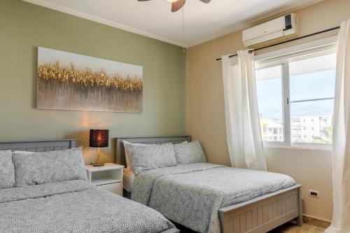 een slaapkamer met 2 bedden en een raam bij Corte Sea A302, Luxury Penthouse in Punta Cana