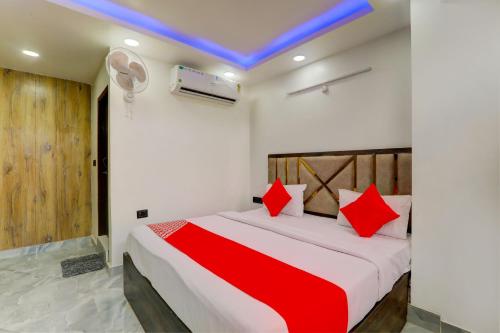 um quarto com uma cama grande e almofadas vermelhas em OYO Flagship Hotel Love Inn em Lucknow