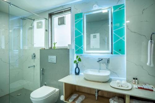 a bathroom with a sink and a toilet and a shower at Inde Hotel Sec- 49, Golf Course Extension, Gurgaon in Gurgaon