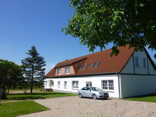 un'auto parcheggiata di fronte a una casa bianca di Ferienwohnungen Hohen Niendorf bei Kühlungsborn a Hohen Niendorf