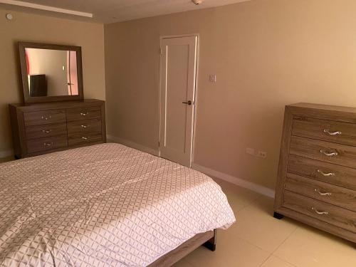 una camera con letto, cassettiera e specchio di Finest Accommodation Bay Front Apt # 609 a Greencastle