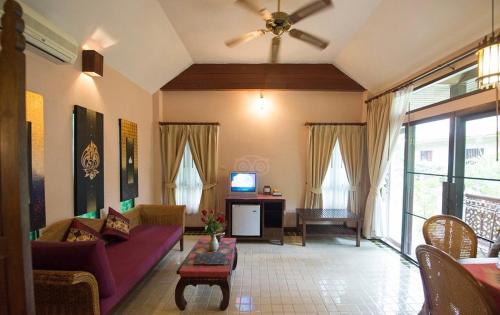 a living room with a couch and a tv at Baan Orapin in Chiang Mai
