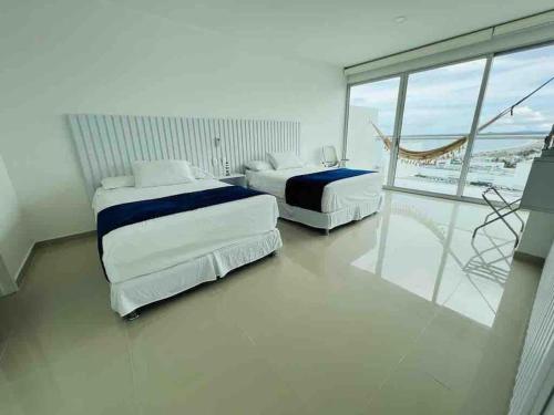 two beds in a room with a view of the ocean at Cartagena in Cartagena de Indias