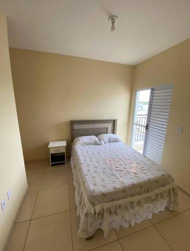 um quarto com uma cama e uma janela em Paulo Eduardo Acomodações em Boituva