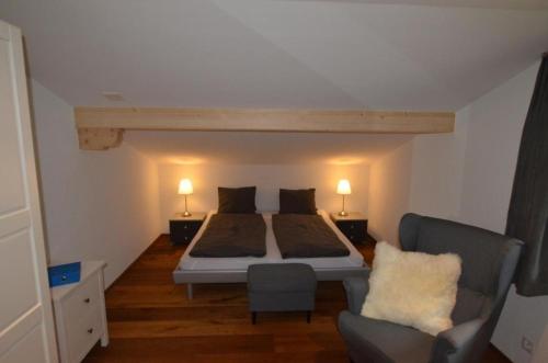 ein Schlafzimmer mit einem Bett und einem Sofa und zwei Lampen in der Unterkunft Chalet Stieregg, Studio West in Grindelwald