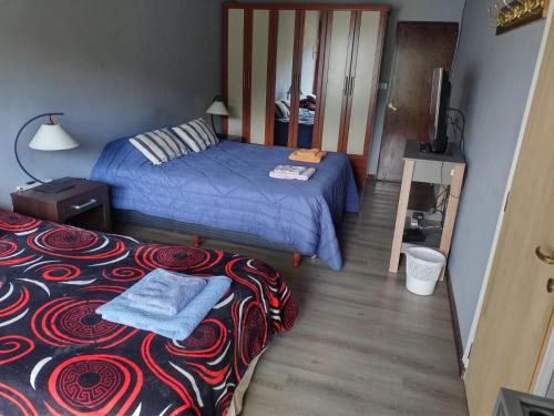 a small bedroom with two beds and a television at Ananda in Ushuaia
