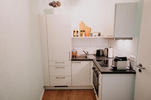 a kitchen with white cabinets and a counter top at Gemütliche Ferienwohnung mit direkter Innenstadtlage in Bingen am Rhein
