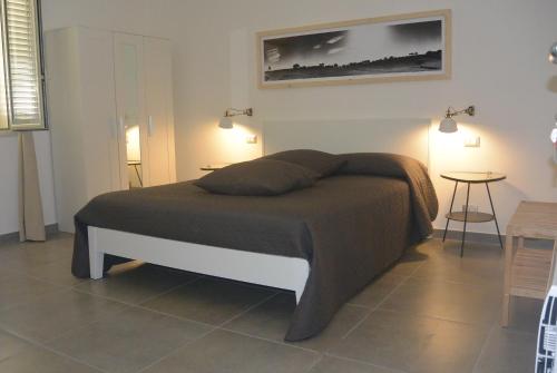 a bed in a bedroom with two lamps and a table at Le Signorine in Cava dʼAliga