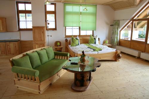 ein Wohnzimmer mit einem Bett, einem Sofa und einem Tisch in der Unterkunft Ferienwohnung Gmeinwieser in Mitterfecking