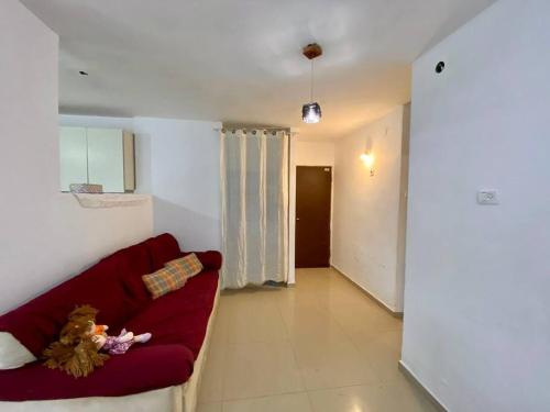 een woonkamer met een rode bank en een hal bij דירת נופש בצפת in Safed