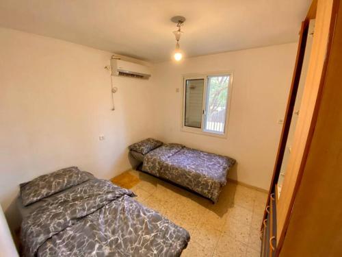 een slaapkamer met 2 bedden en een raam bij דירת נופש בצפת in Safed