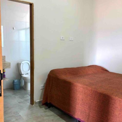 a bedroom with a bed and a toilet in a room at Sossego e Boa Vista in Ilhabela