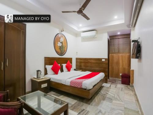 a bedroom with a bed with red pillows at Super OYO Chand Palace - Managed by Company in New Delhi