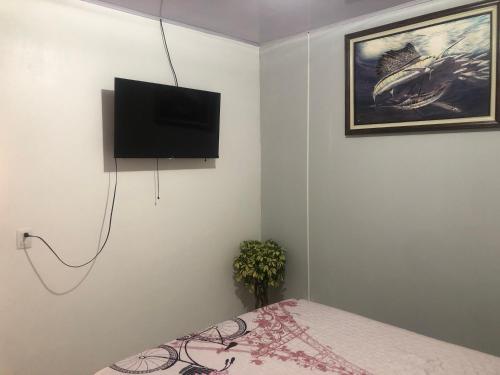 ein Schlafzimmer mit einem Bett und einem TV an der Wand in der Unterkunft Apartamento BYES in Quepos