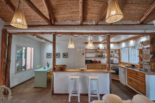 uma cozinha com tectos em madeira e um balcão com bancos em Bolonia Beach Campus em Tarifa