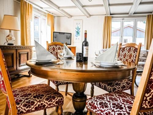 ein Esszimmer mit einem Tisch und einer Flasche Wein in der Unterkunft Chalet Lilo 4 Zimmer big view in Beatenberg