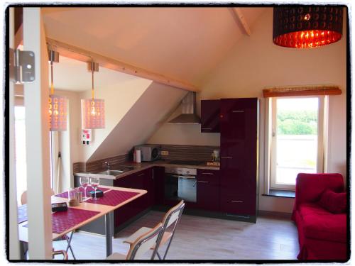 a kitchen with a table and a red counter top at Archipel Holiday Cottage in Ellezelles