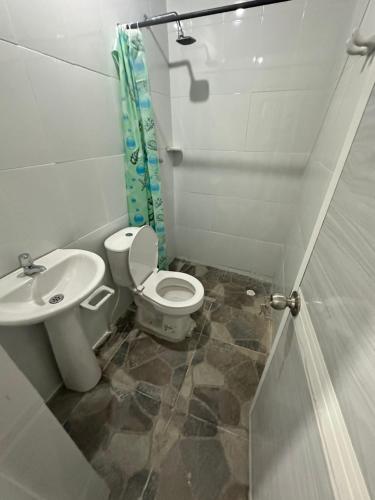 uma casa de banho com um WC e um lavatório em Hostal el viajero em Soledad