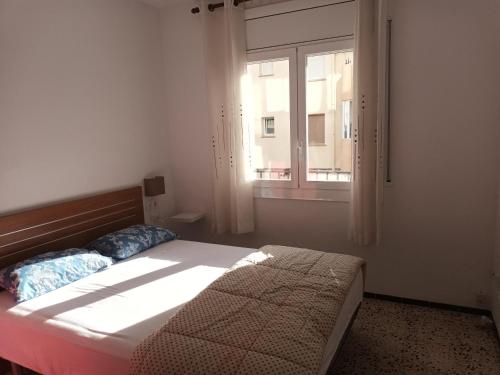 1 dormitorio con cama y ventana en Apartamento Roses, 1 dormitorio, 4 personas - ES-258-61, en Roses
