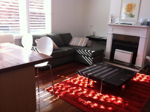 a living room with a couch and a fireplace at 105MitrePlantationHouseBathurst in Bathurst
