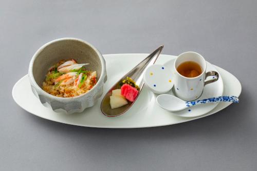 a plate with a bowl of food and a cup of tea at Fugaku Gunjo in Izu